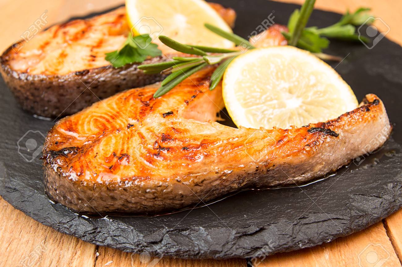 Grilled Trout Fillet On Frying Pan Steak Of Trout Garnish Lemon On Black Slate Wooden Background Healthy Delisious Food Concept Top View View From Above Healthy Delisious Food Concept Stock Photo Picture