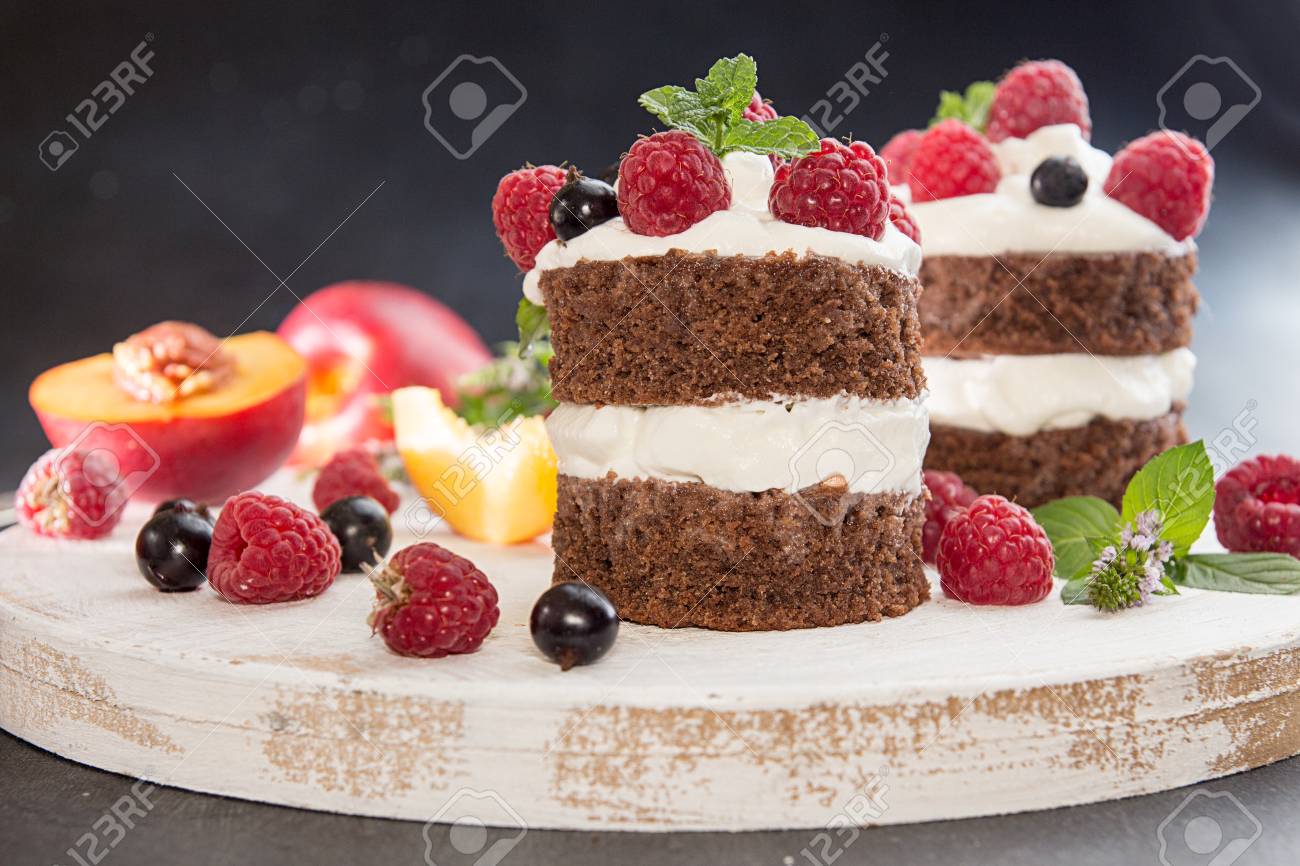 Gateau Au Chocolat Decore De Framboise De Cassis De Nectarine De Creme Fraiche Et De Menthe Sur Planche De Bois Blanc Sur Fond Fonce Banque D Images Et Photos Libres De Droits Image