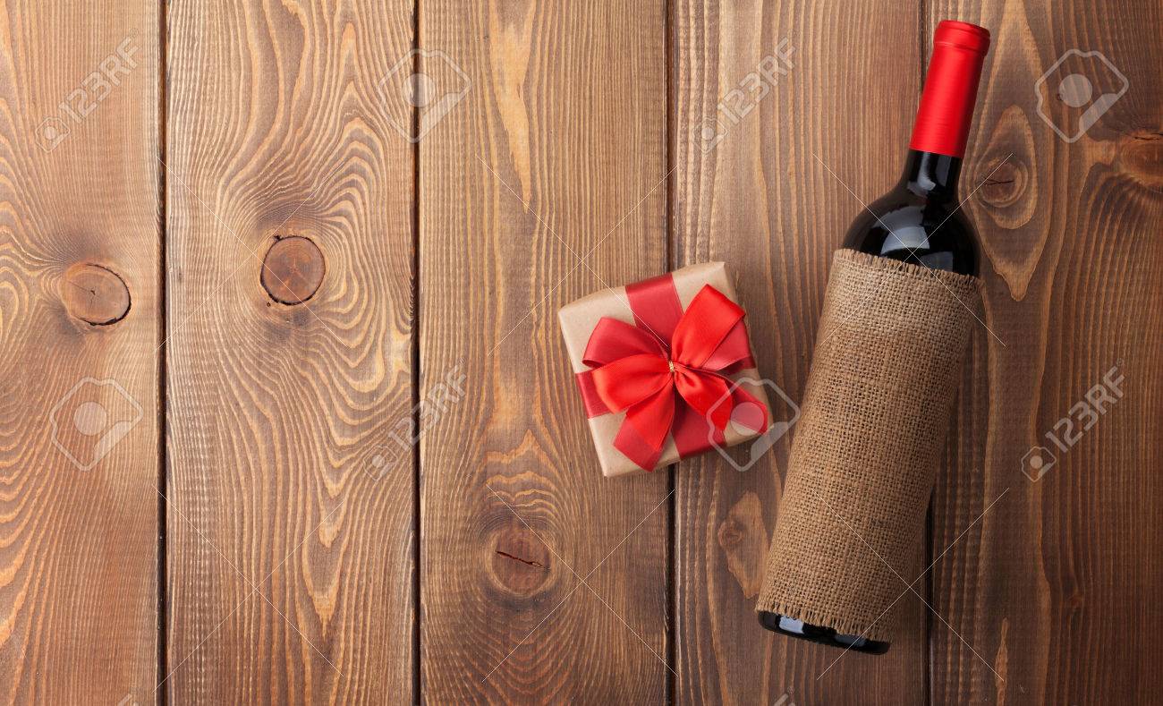 Red Wine Bottle And Valentines Day Gift Box Over Rustic Wooden Table Background With Copy Red Wine Bottle And Valentines Day Gift Box Over Rustic Wooden Table Background With Copy