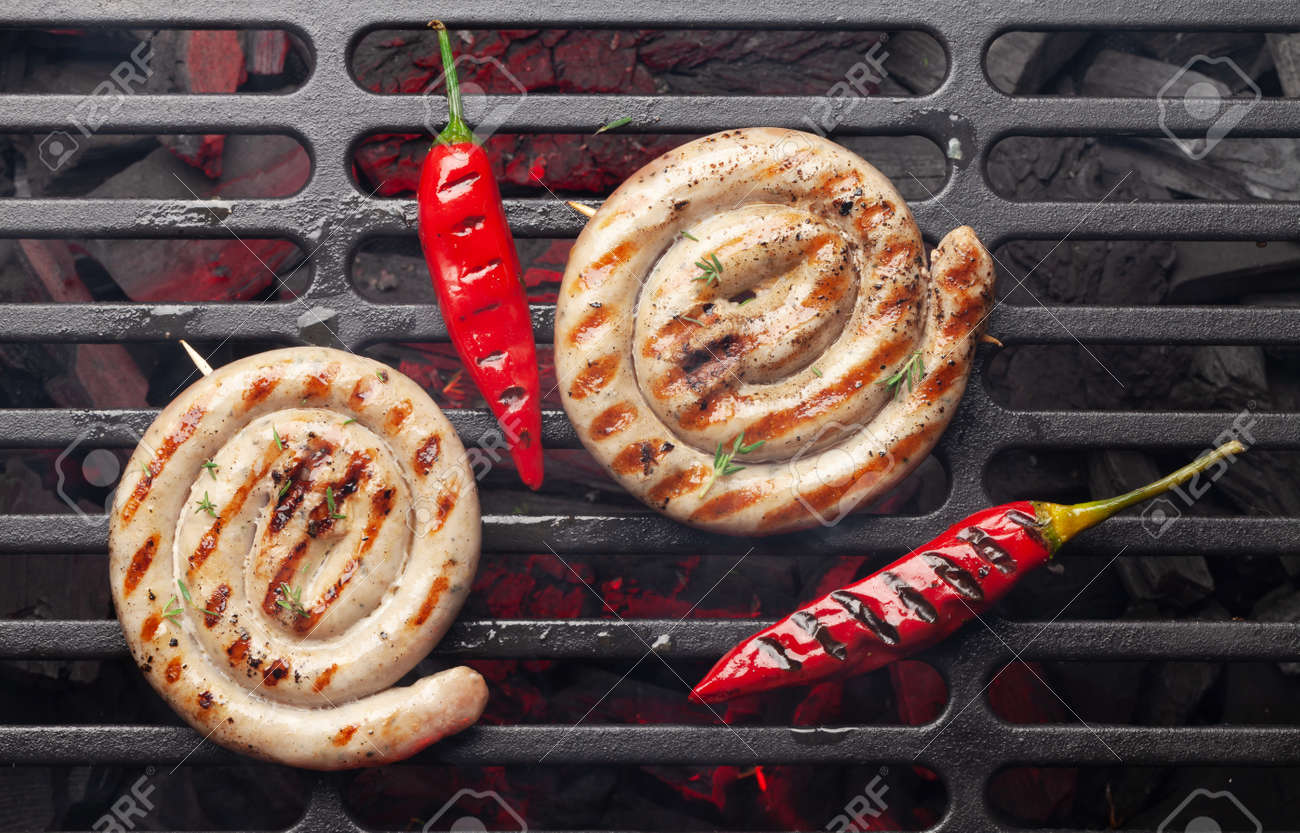Hot spicy grilled sausages on coal grill. Top view flat lay - 169438310 Hot spicy grilled sausages on coal grill. Top view flat lay - 169438310