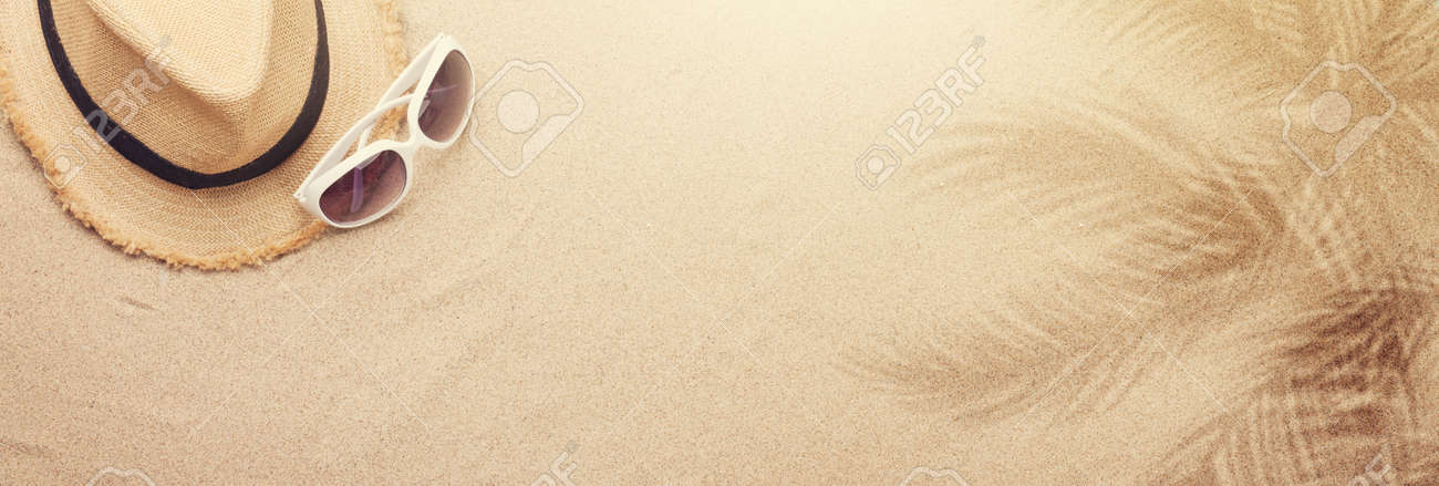 Travel vacation background concept with sunglasses and beach hat on sand backdrop. Top view with copy space. Flat lay - 169317596 Travel vacation background concept with sunglasses and beach hat on sand backdrop. Top view with copy space. Flat lay - 169317596
