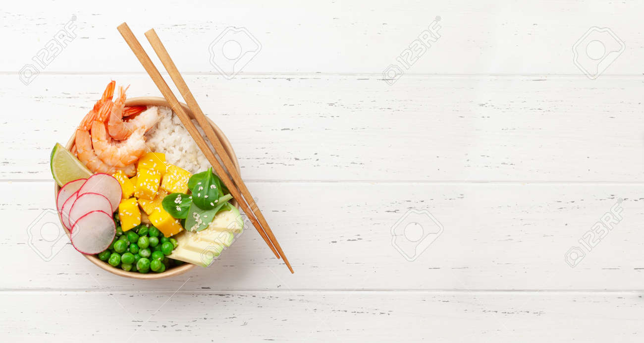 Poke bowl with shrimps, avocado and mango. Traditional hawaiian meal. Top view flat lay with copy space - 169549609 Poke bowl with shrimps, avocado and mango. Traditional hawaiian meal. Top view flat lay with copy space - 169549609