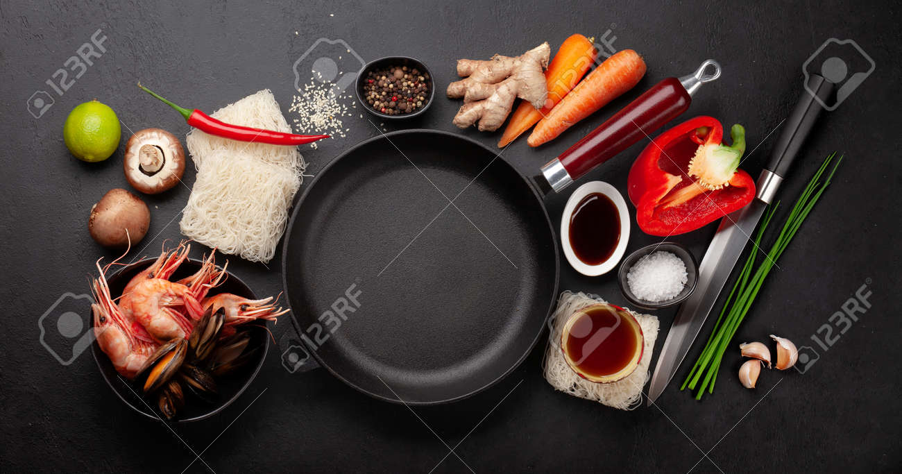 Ingredients for wok cooking with stir fried noodles, shrimps and vegetables on stone background. Top view flat lay with copy space - 169549804 Ingredients for wok cooking with stir fried noodles, shrimps and vegetables on stone background. Top view flat lay with copy space - 169549804
