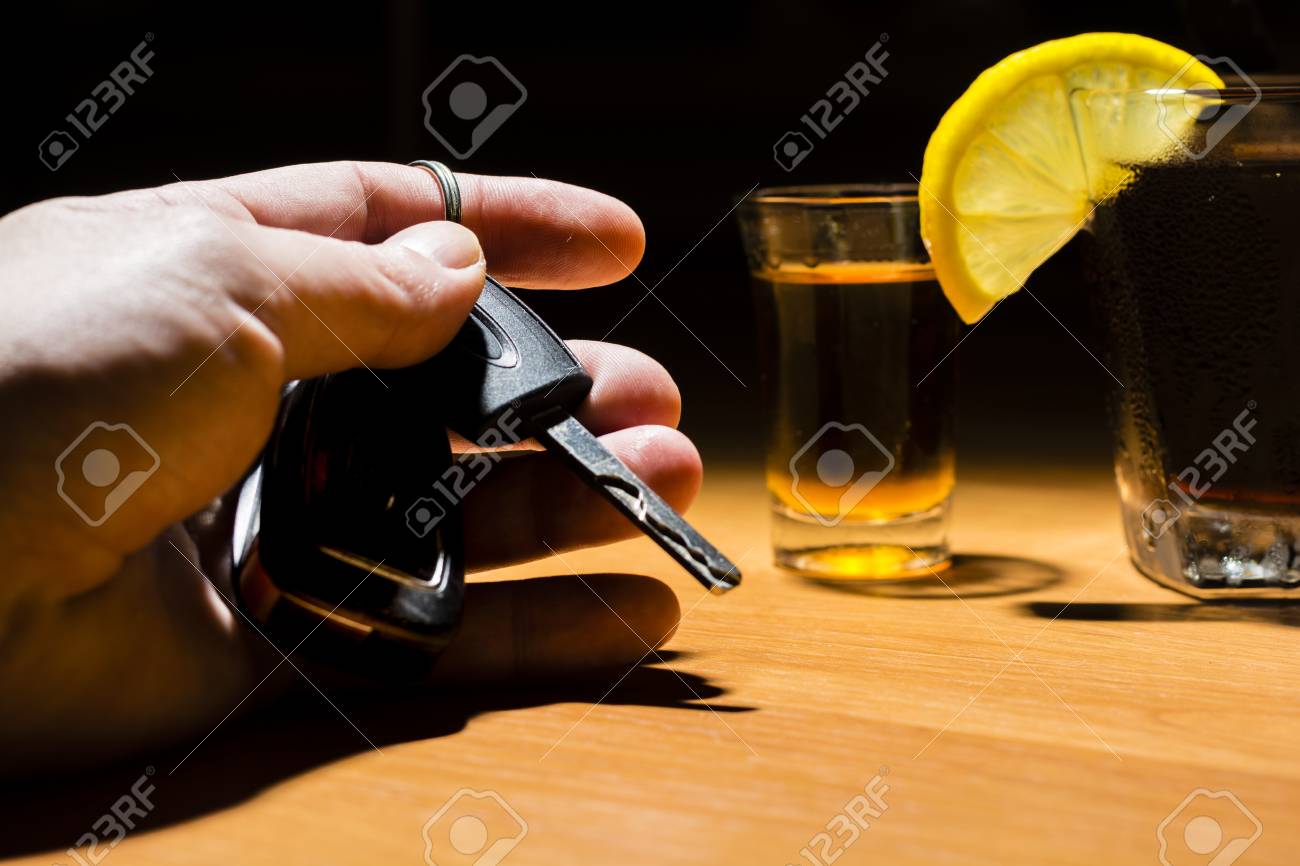 A Mans Hand Holding Car Keys At A Bar Whiskey And Cocktail - 