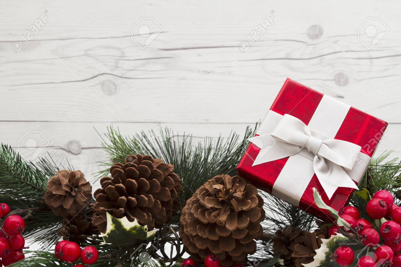 Albero Di Natale Con Pigne E Bacche.Immagini Stock Vecchia Priorita Bassa Di Natale Di Modo Ghirlanda Con Un Regalo Di Natale Pigne E Bacche Rosse Dell Agrifoglio Su Priorita Bassa Di Legno Esposta All Aria Con Lo Spazio Della