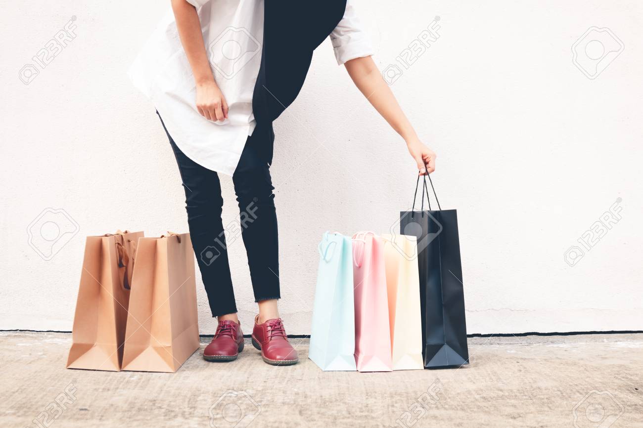 Woman Wear Black Jeans Holding Shopping Bag On The Ground Stock
