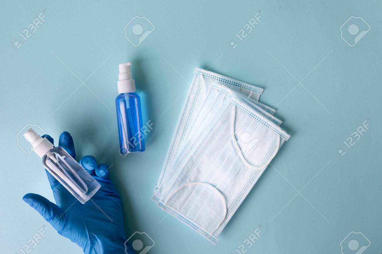 medical concept on a blue background. Means of protection against the virus: medical mask, antiseptics, hand hygiene products, sanitizers. Hand of a man in a medical glove. - 143669026 medical concept on a blue background. Means of protection against the virus: medical mask, antiseptics, hand hygiene products, sanitizers. Hand of a man in a medical glove. - 143669026