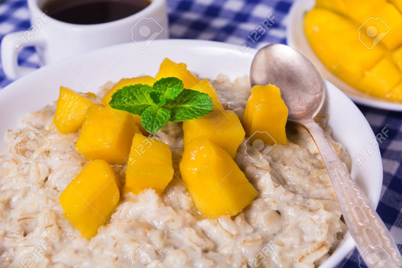 Gachas De Avena Con Mango Fresco En El Cuenco Blanco Con Cafe Y Libro Fotos Retratos Imagenes Y Fotografia De Archivo Libres De Derecho Image