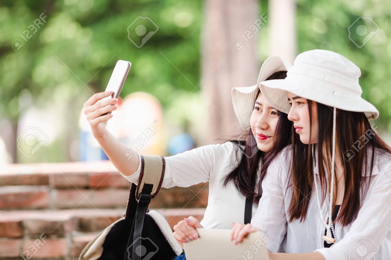 Asian young women tourists taking a selfie in city - 122269910 Asian young women tourists taking a selfie in city - 122269910