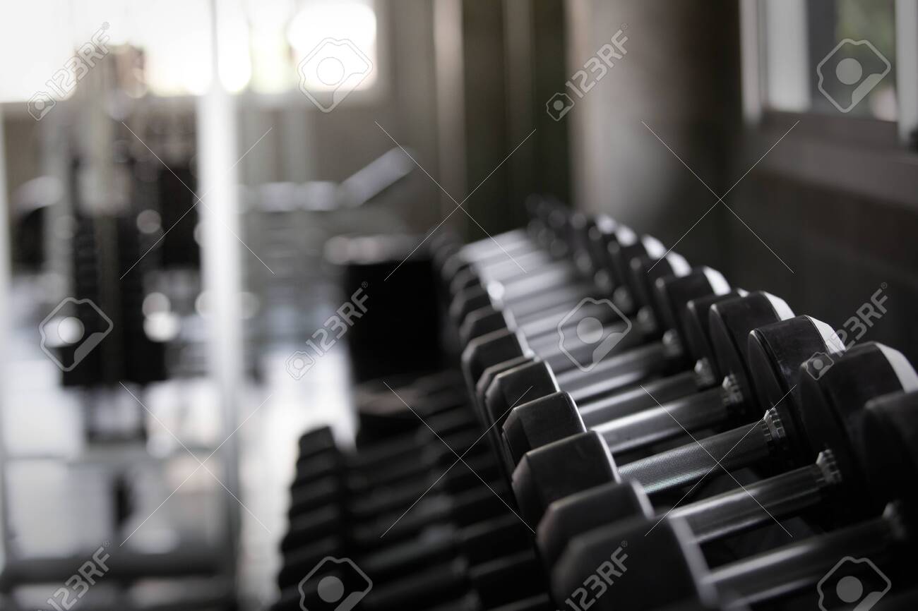 Background view back and white equipment dumbbells on rack in the gym sport center - 122270040 Background view back and white equipment dumbbells on rack in the gym sport center - 122270040