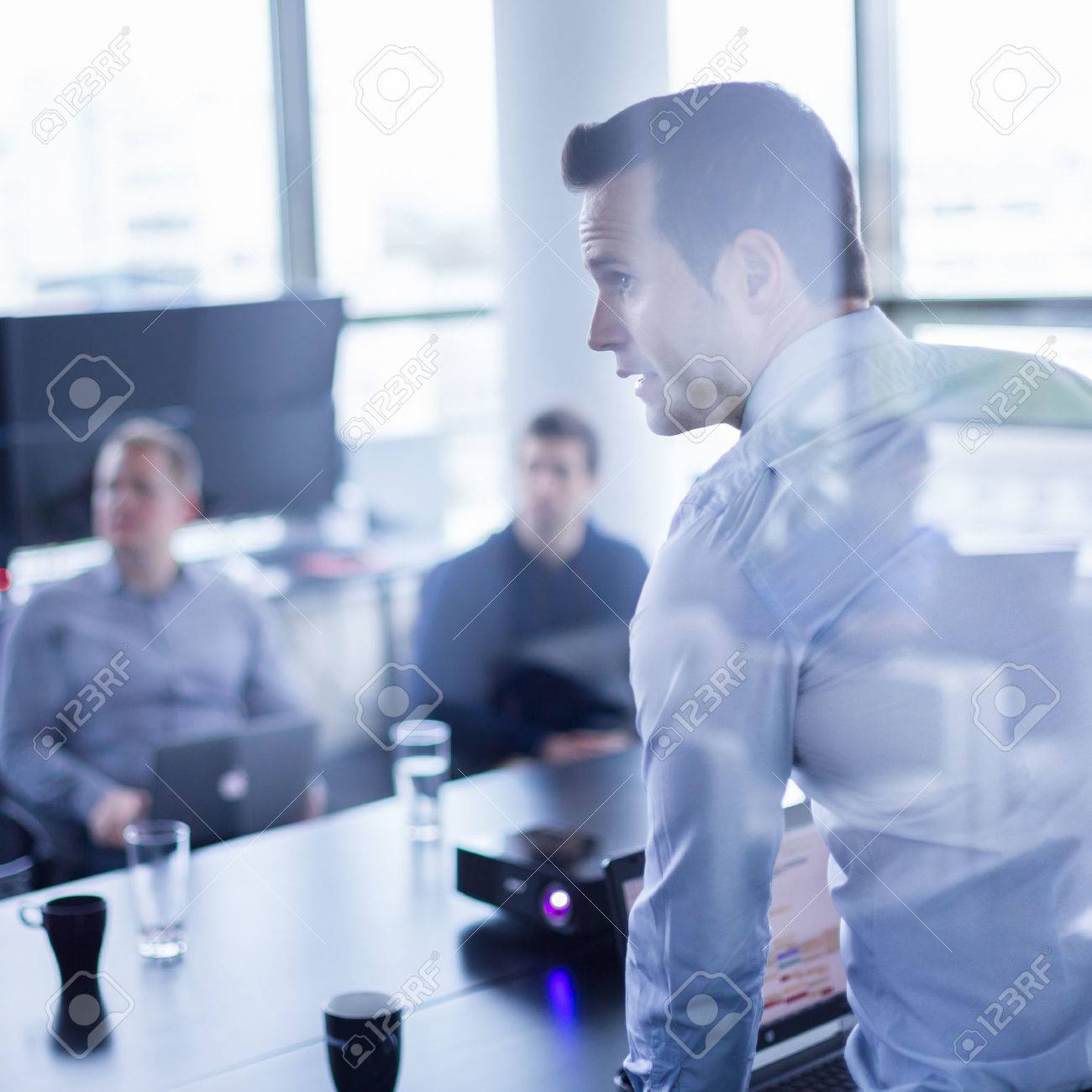 Business man making a presentation at office. Business executive delivering a presentation to his colleagues during meeting or in-house business training, explaining business plans to his employees. - 42193091 Business man making a presentation at office. Business executive delivering a presentation to his colleagues during meeting or in-house business training, explaining business plans to his employees. - 42193091