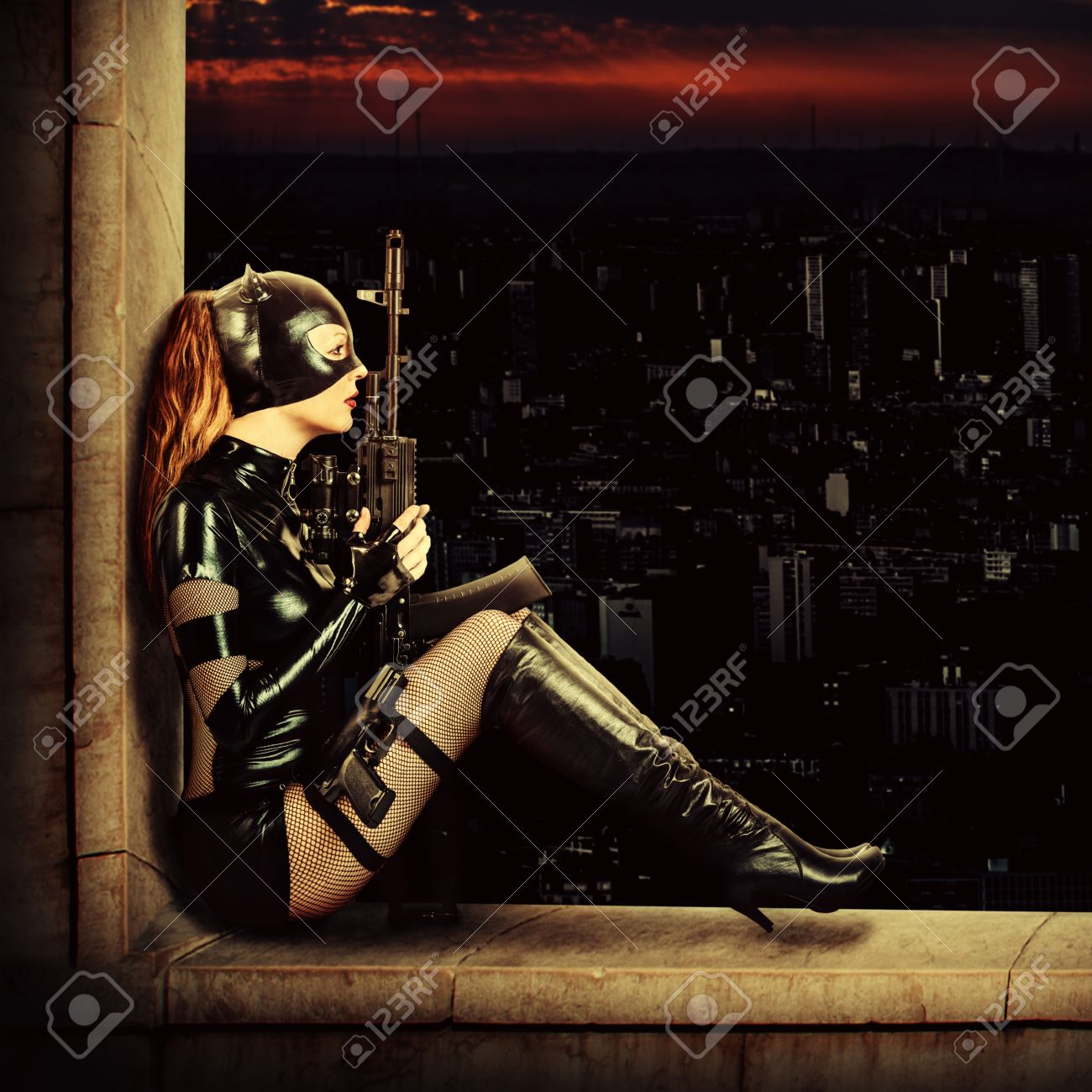 ファンタジー 自動銃を保持しているラテックスの猫のスーツでセクシーな女性の軍事狙撃 の写真素材 画像素材 Image