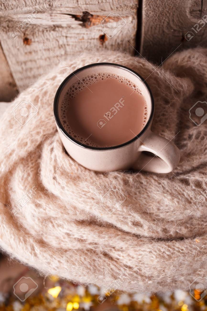Details of still life in the home interior living room. Beautiful Cup of hot cocoa or chocolate and sweaters on wooden background . Cosy autumn-winter concept - 109743538 Details of still life in the home interior living room. Beautiful Cup of hot cocoa or chocolate and sweaters on wooden background . Cosy autumn-winter concept - 109743538