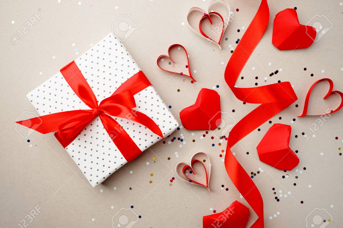 Gift Box With Red Bow Ribbon And Red Origami Paper Heart On Gray