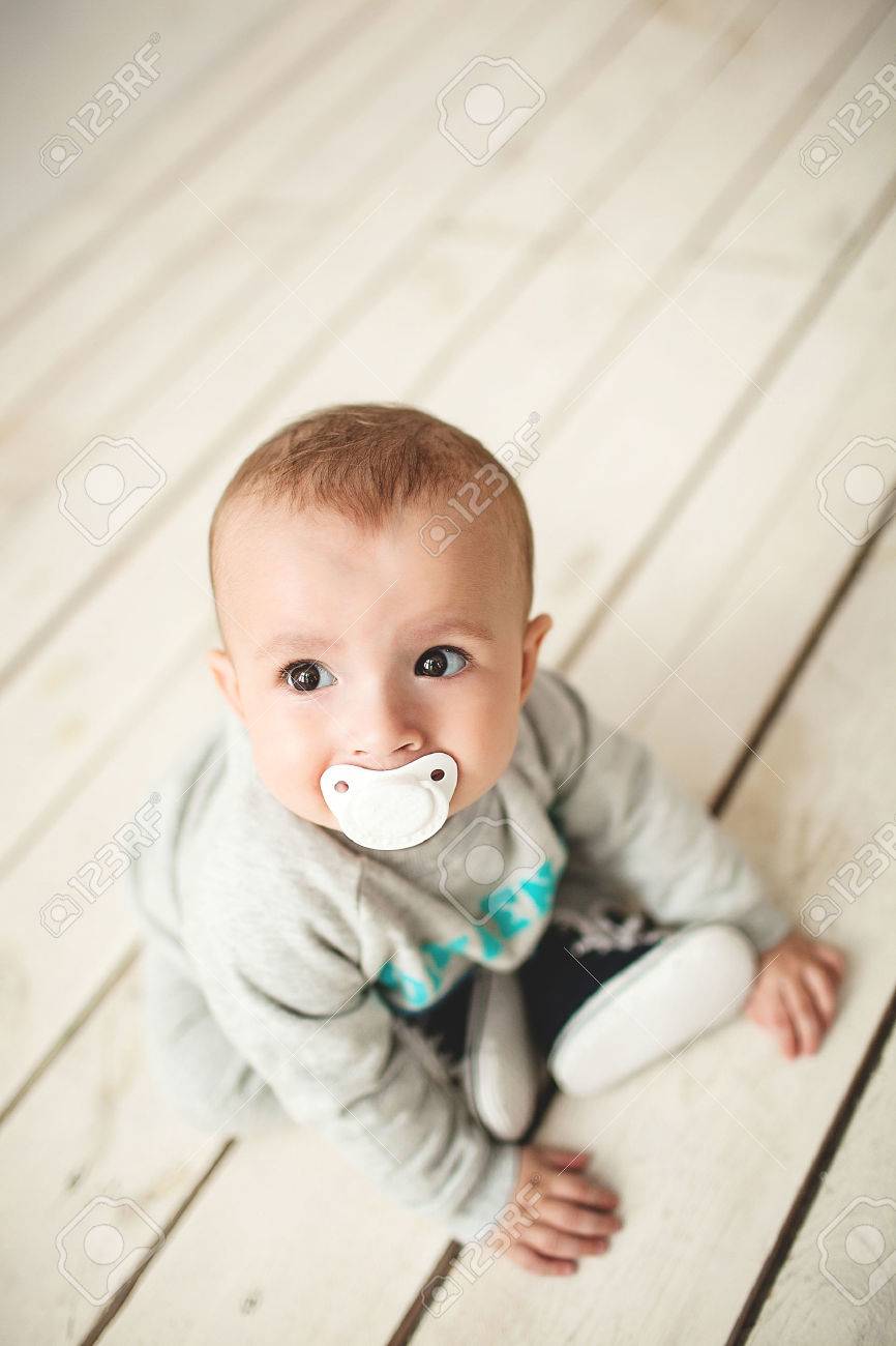 1 歳のかわいい男の子が白で素朴な木製の床の上に座って の写真素材 画像素材 Image