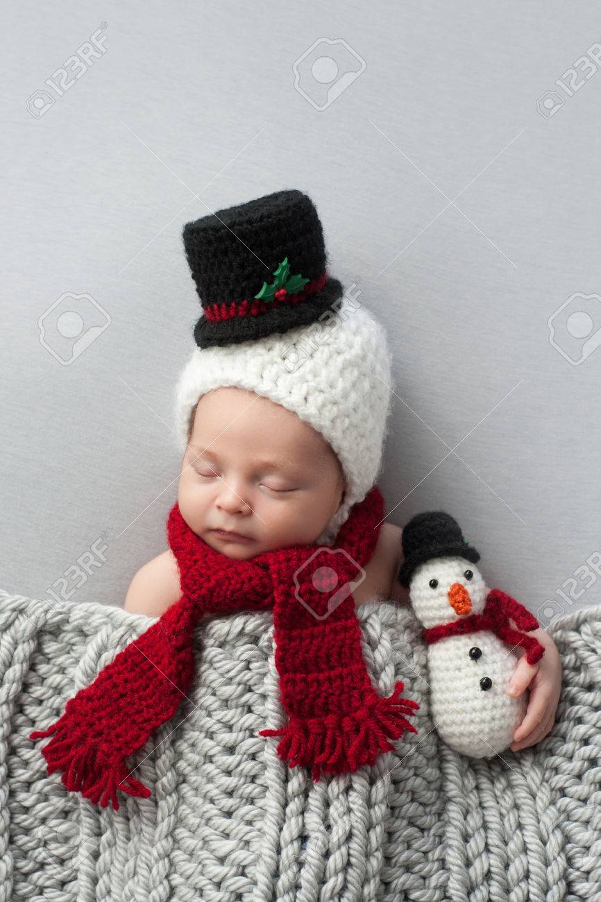 かぎ針編みの雪だるまボンネットやスカーフを身に着けている 2 週古い 新生児 赤ちゃんの男の子 彼は一致するぬいぐるみを保持は 光の灰色の布の上で眠っています の写真素材 画像素材 Image