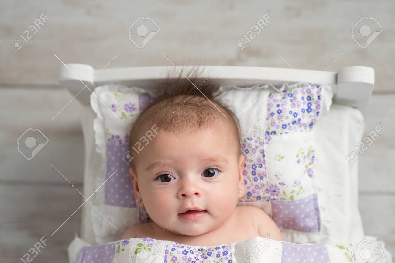 Un Coup De Tete D Un Bebe De Quatre Mois Alerte Petite Fille Elle Se Couche Dans Un Petit Lit Et Regarde La Camera Banque D Images Et Photos Libres De Droits Image