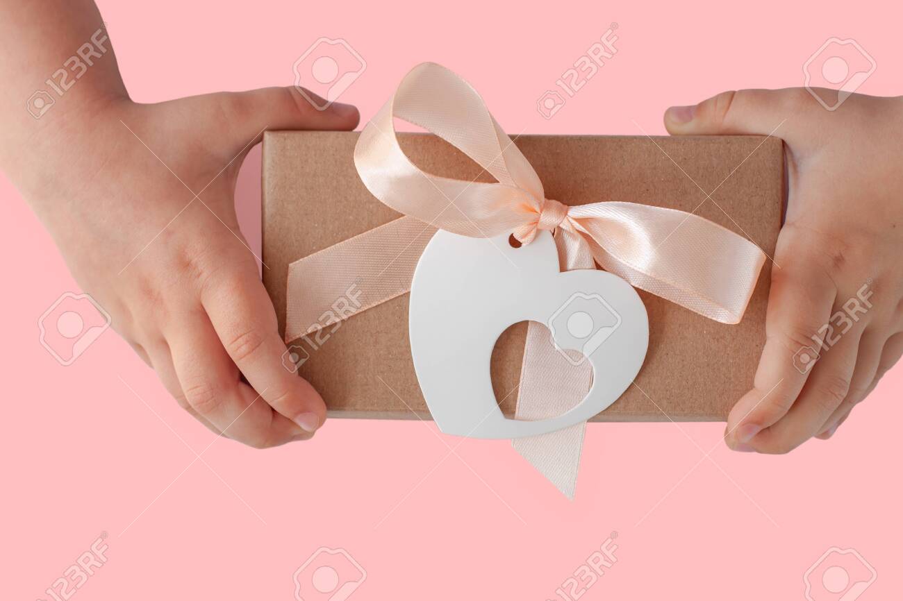 Download Children Hands Hold Gift Box With Ribbon Bow And Heart Card Tag Stock Photo Picture And Royalty Free Image Image 144304773