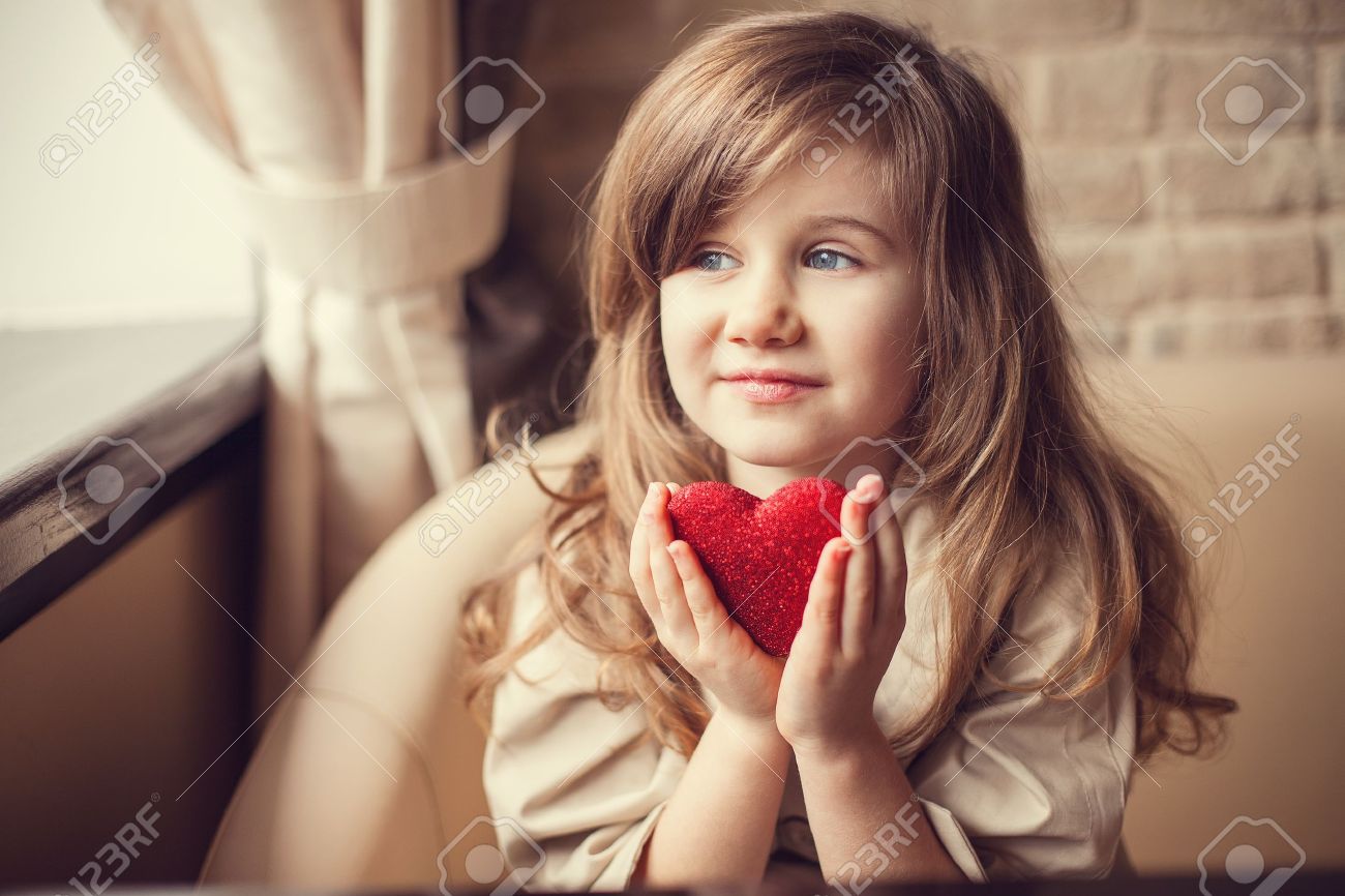 Valentine Day - dreaming cute child with red Heart in hands. - 17809989 Valentine Day - dreaming cute child with red Heart in hands. - 17809989