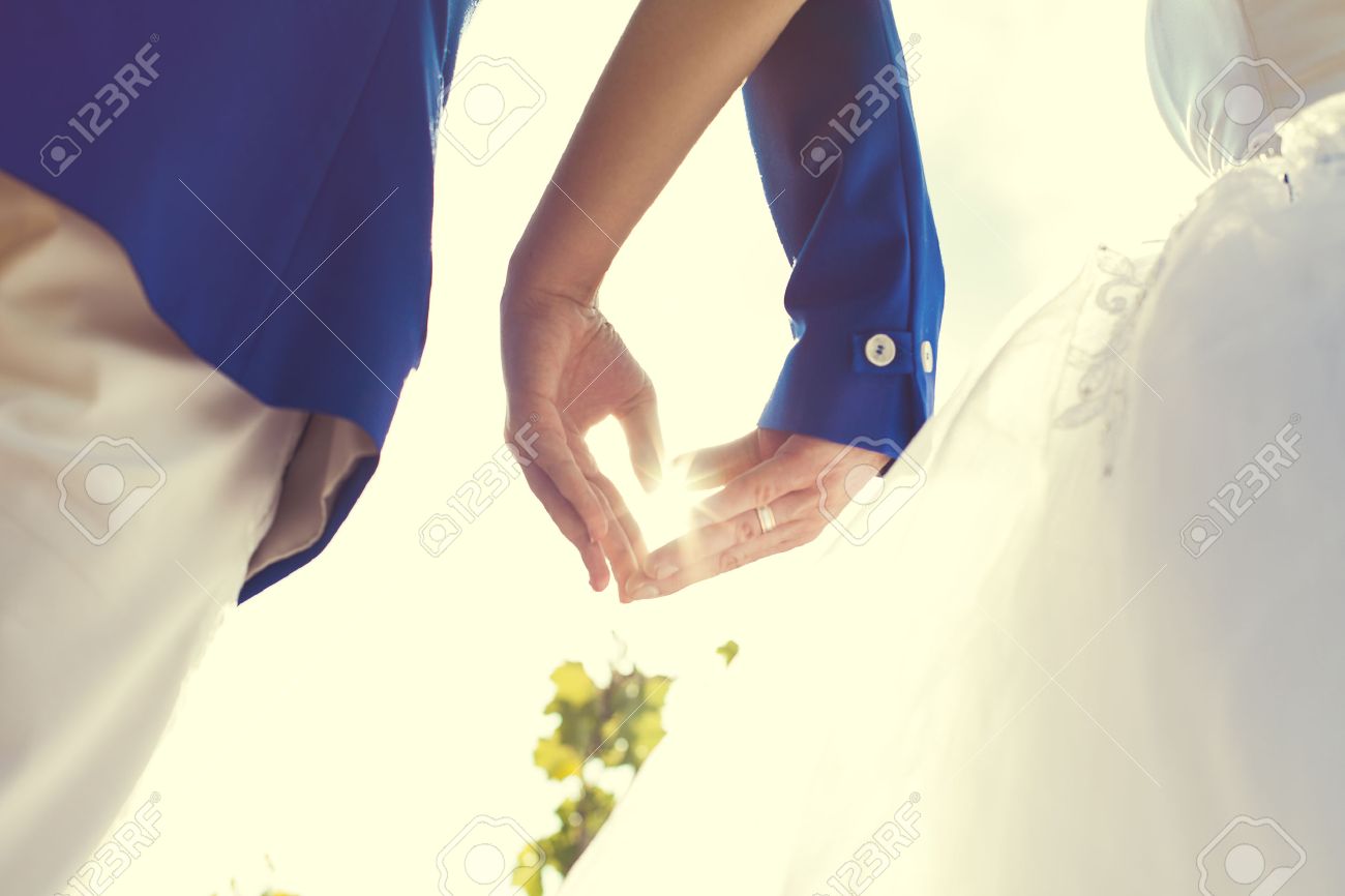 wedding couple hands touching fingers in the shape of hearts. Bright light of the sun on . - 24421987 wedding couple hands touching fingers in the shape of hearts. Bright light of the sun on . - 24421987