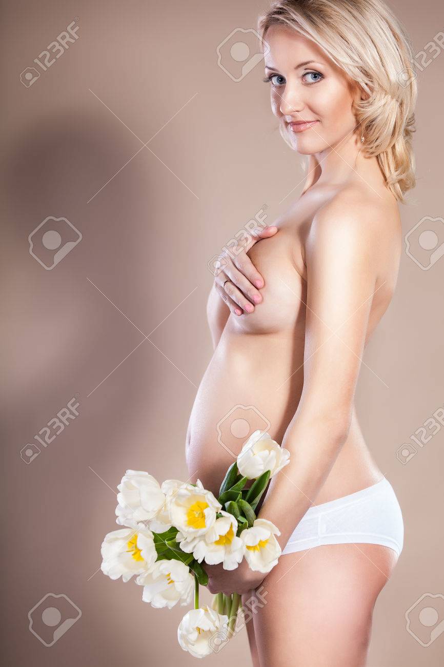 花の花束を保持している裸の妊娠中の女性 の写真素材 画像素材 Image