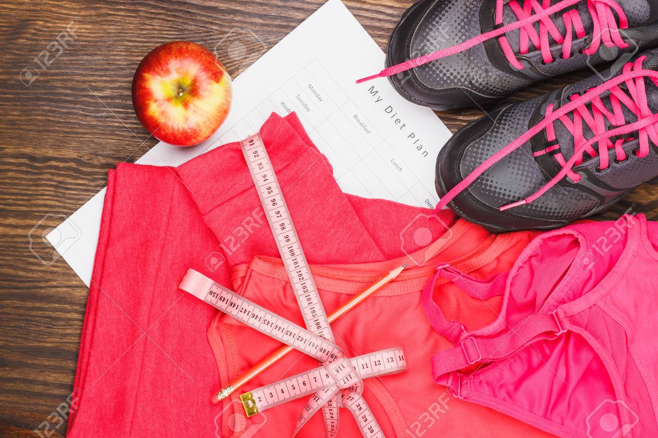 Artículos Deportivos: Zapatillas De Deporte, Cinta Métrica Y Ropa Deportiva En El Fondo De Madera Retratos, Imágenes Y Fotografía De Archivo Libres De Image 58990544.