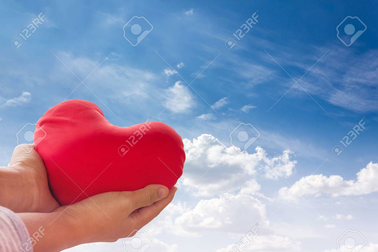 Romantique Belle Concept De Valentine Avec La Main Souleve Doucement Coeur Rouge Sur Fond De Ciel Bleu Banque D Images Et Photos Libres De Droits Image