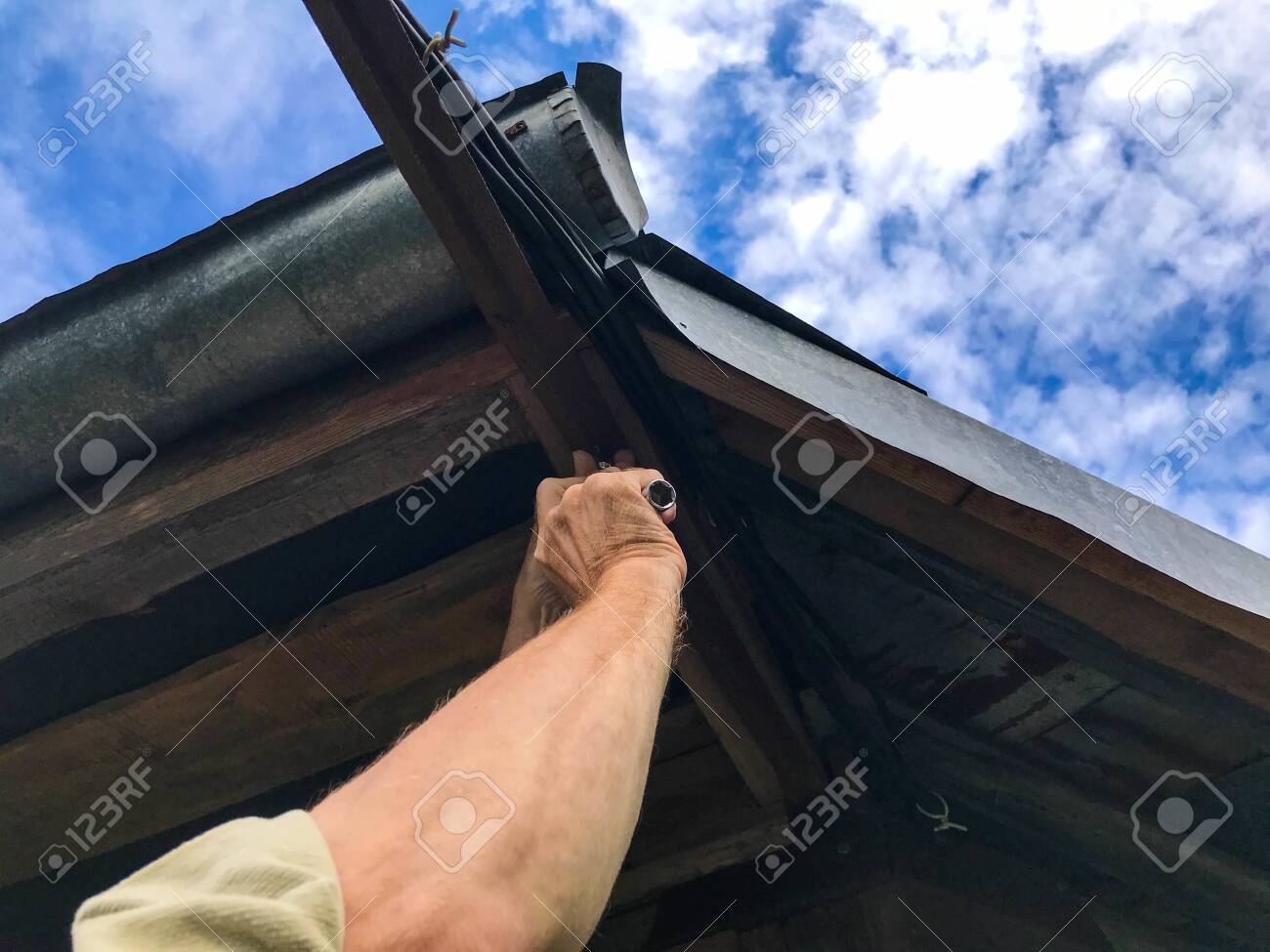 Man Repairs The Roof At A Height Manufacturing In A Wooden Stock Photo Picture And Royalty Free Image Image 156096122