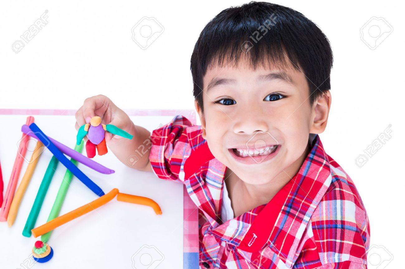 little asian boy playing and creating toys from play dough child child works child play
