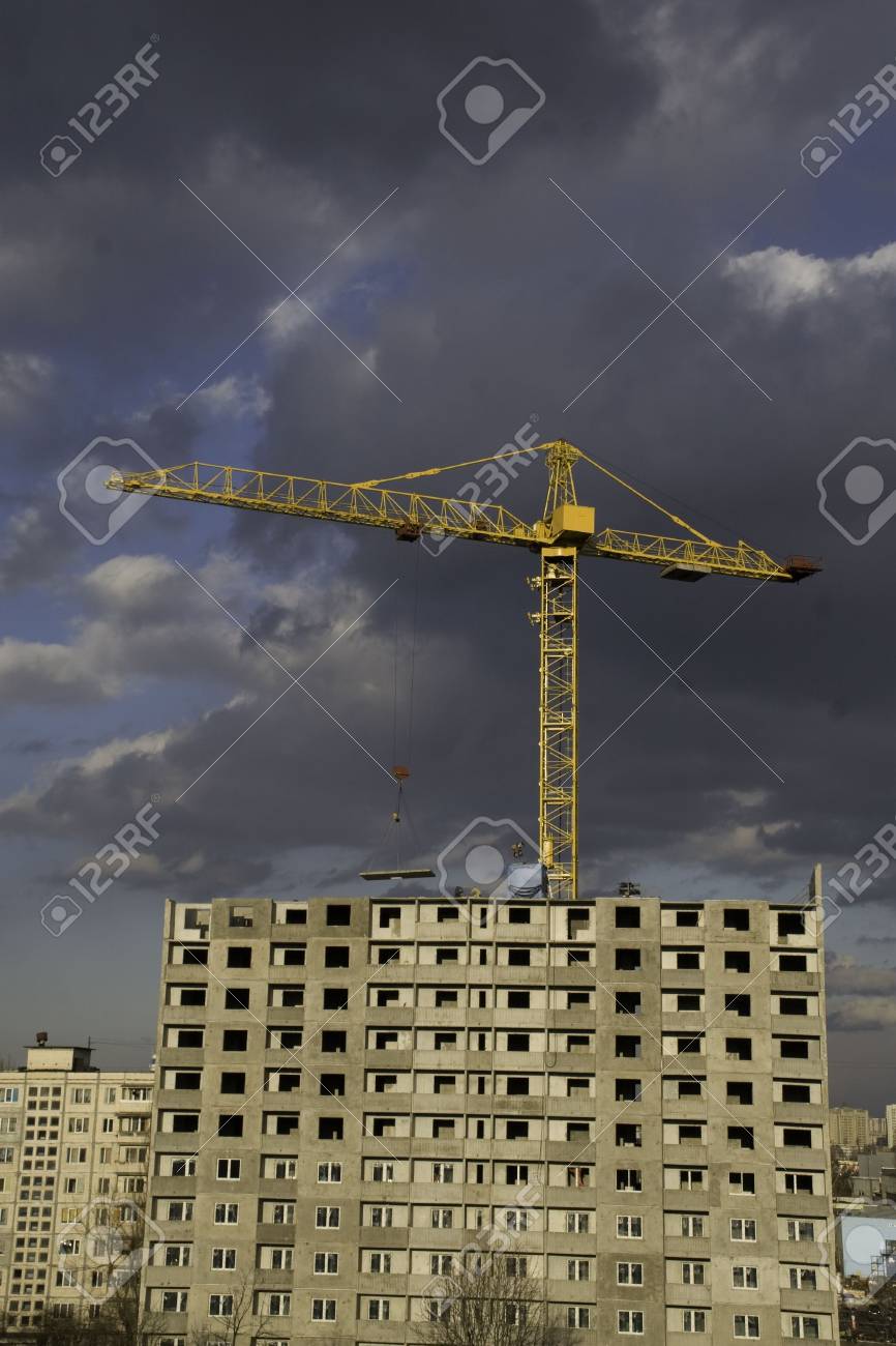 hoisting crane lifting a concrete slab on a house being built on the background of - House Built On Concrete Slab hoisting crane lifting a concrete slab on a house being built on the background of - House Built On Concrete Slab