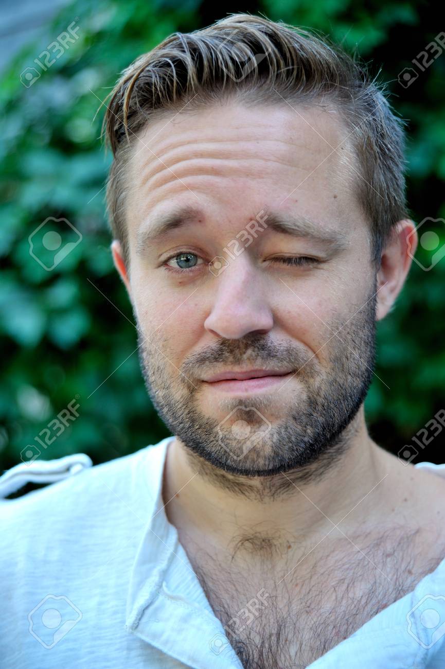 Portrait Of Young Bearded Man Winking With His Left Eye Outdoor Stock  Photo, Picture and Royalty Free Image. Image 45067921., image size:865x1300