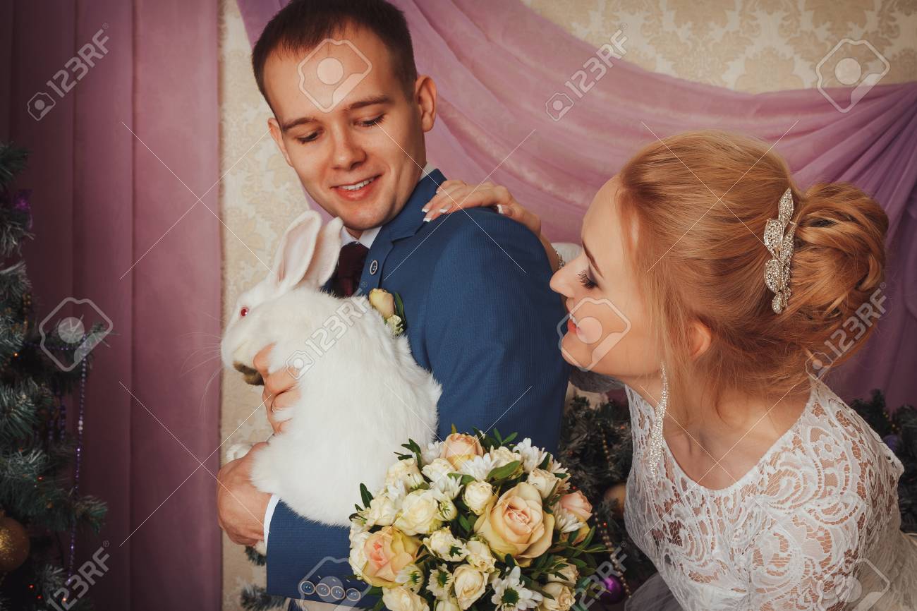 Beautiful Bride In A White Dress And A Young Groom In A Blue