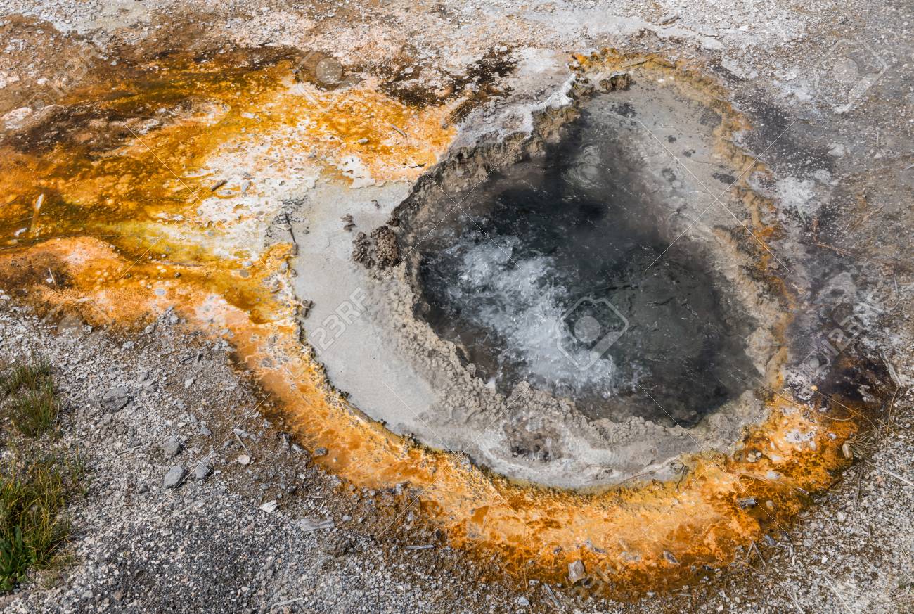 orange sulfur ring around bubbling hot spring with clear water sulfur in water