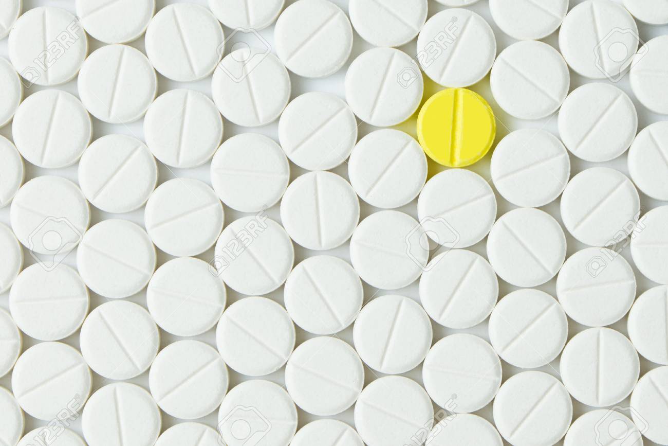 Yellow tablet among the white forming background - 64107510 Yellow tablet among the white forming background - 64107510