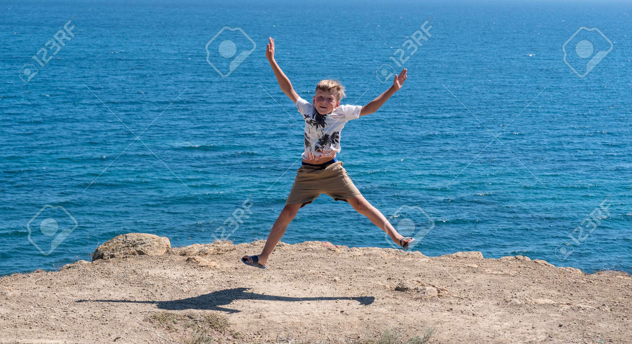 A fair-haired boy against the blue sea. - 155752464 A fair-haired boy against the blue sea. - 155752464