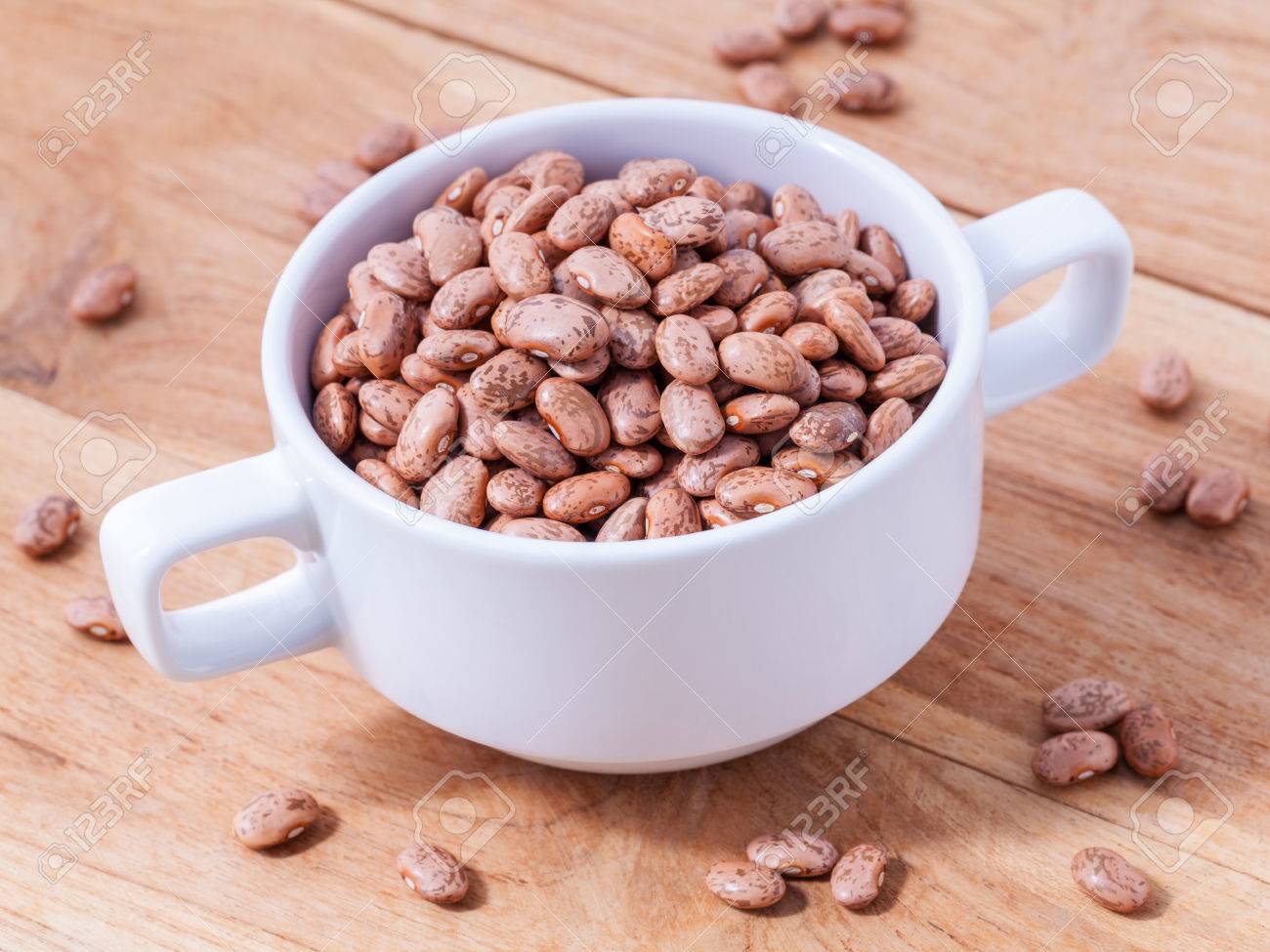 Brown pinto beans in the bowl and brown pinto beans background. - 47997524 Brown pinto beans in the bowl and brown pinto beans background. - 47997524