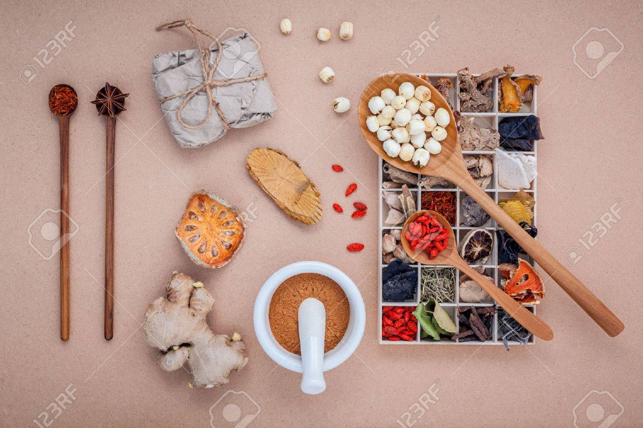 Alternative health care dried various Chinese herbs in wooden box , dried quince ,ginger and lotus seed in wooden spoon with mortar on brown background. - 51663137 Alternative health care dried various Chinese herbs in wooden box , dried quince ,ginger and lotus seed in wooden spoon with mortar on brown background. - 51663137