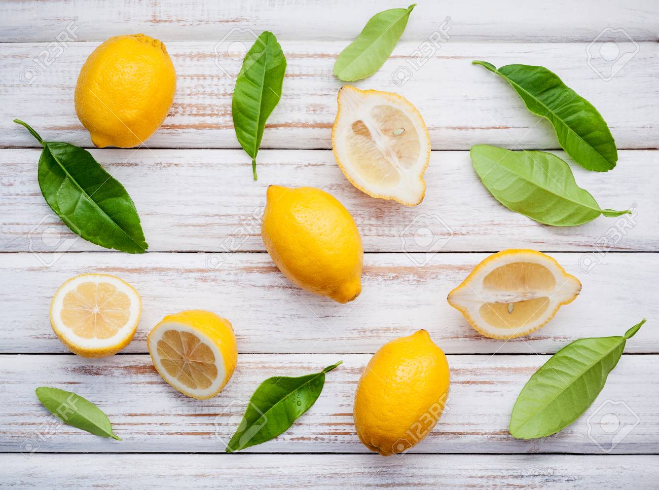 fresh lemons and lemons leaves on rustic wooden background