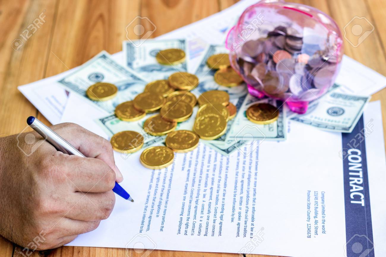 law to a a that are Businessmen a pen loan agreement.. sign holding