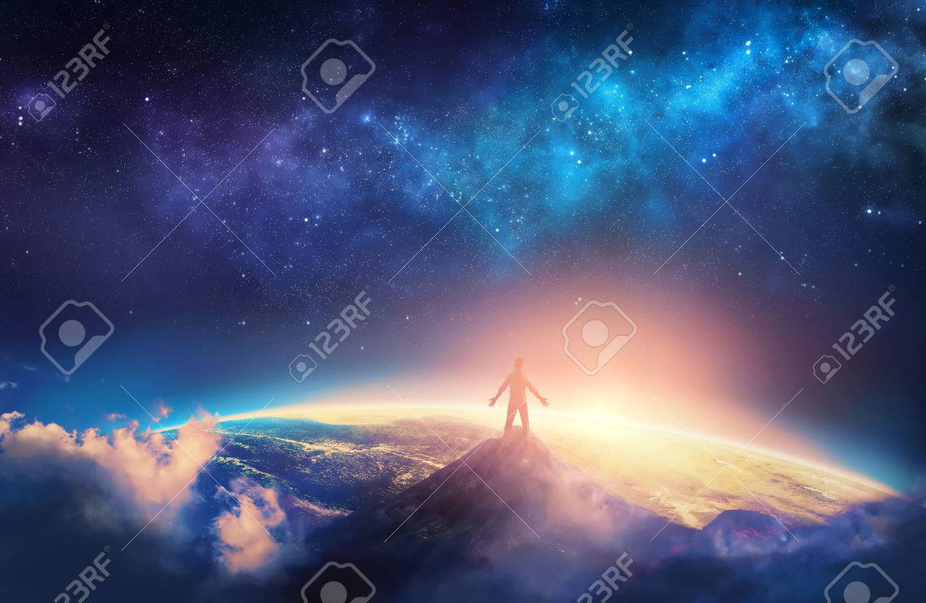 A man climbs a high mountain and lifts his arms up in praise - 74918940 A man climbs a high mountain and lifts his arms up in praise - 74918940