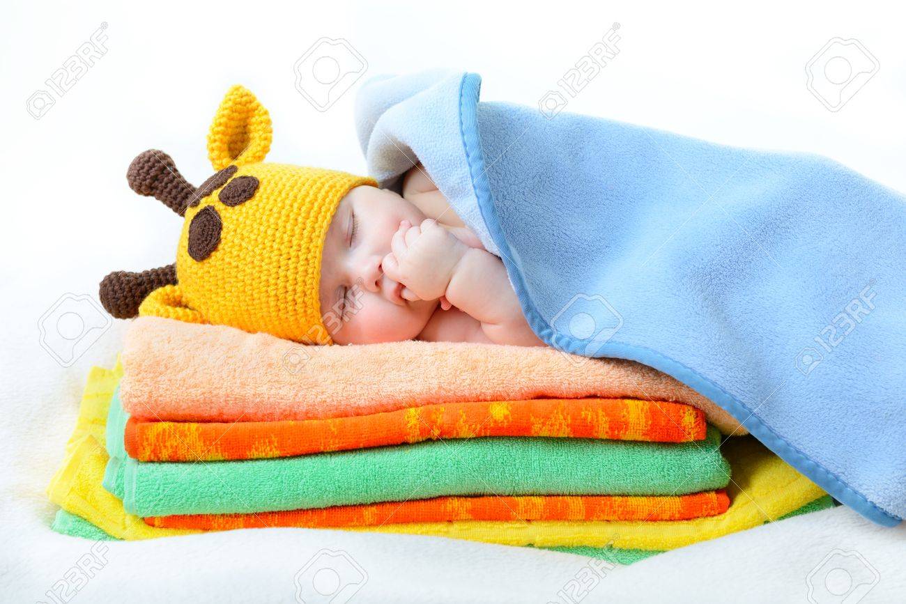 Cute Sleeping Baby Boy In Funny Hand Made Giraffe Hat Beautiful Kid Dozing On Pile Cute Sleeping Baby Boy In Funny Hand Made Giraffe Hat Beautiful Kid Dozing On Pile