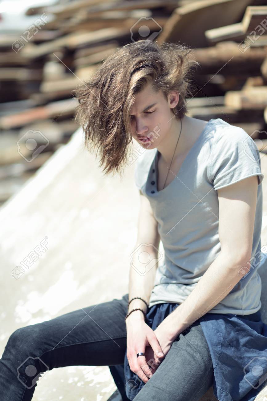Portrait Of Young Handsome Man Over Wood Boards, Outdoor. Attractive Trendy  Fashion 18 Years Old Teen Boy Posing Outside Over Debris Stock Photo,  Picture and Royalty Free Image. Image 80888548.