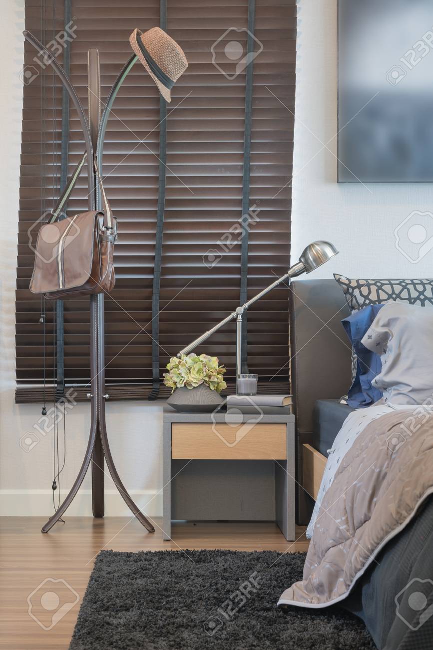 Hat And Bag Hanging On Clothes Hanger Rack With Modern Lamp In