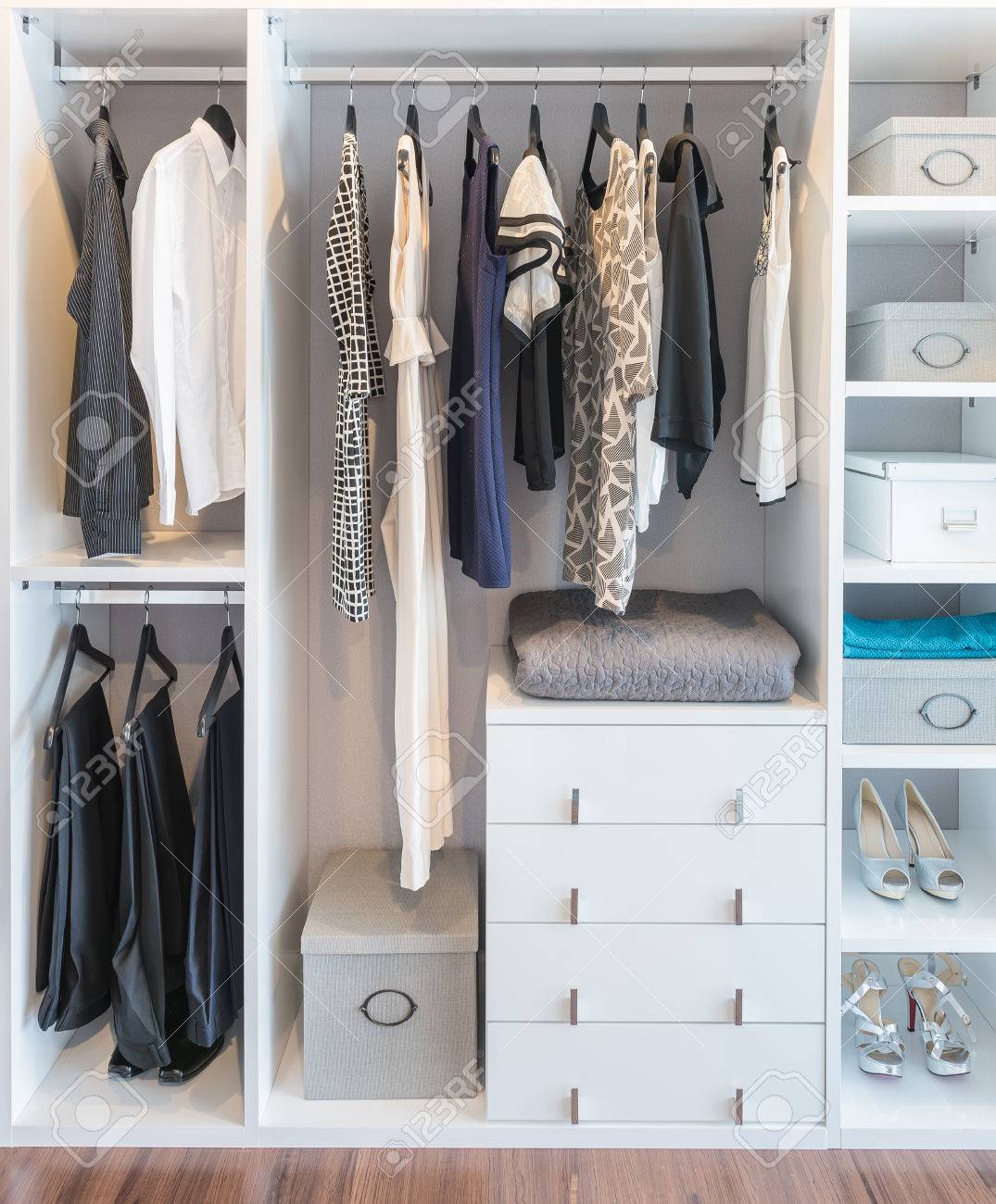 Clothes Hanging On Rail In White Wardrobe With Box And Shoes Stock