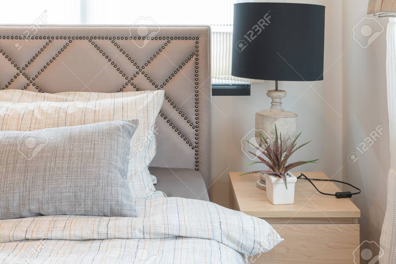 Einzelnes bett im modernen schlafzimmer mit schwarzer lampe und vase