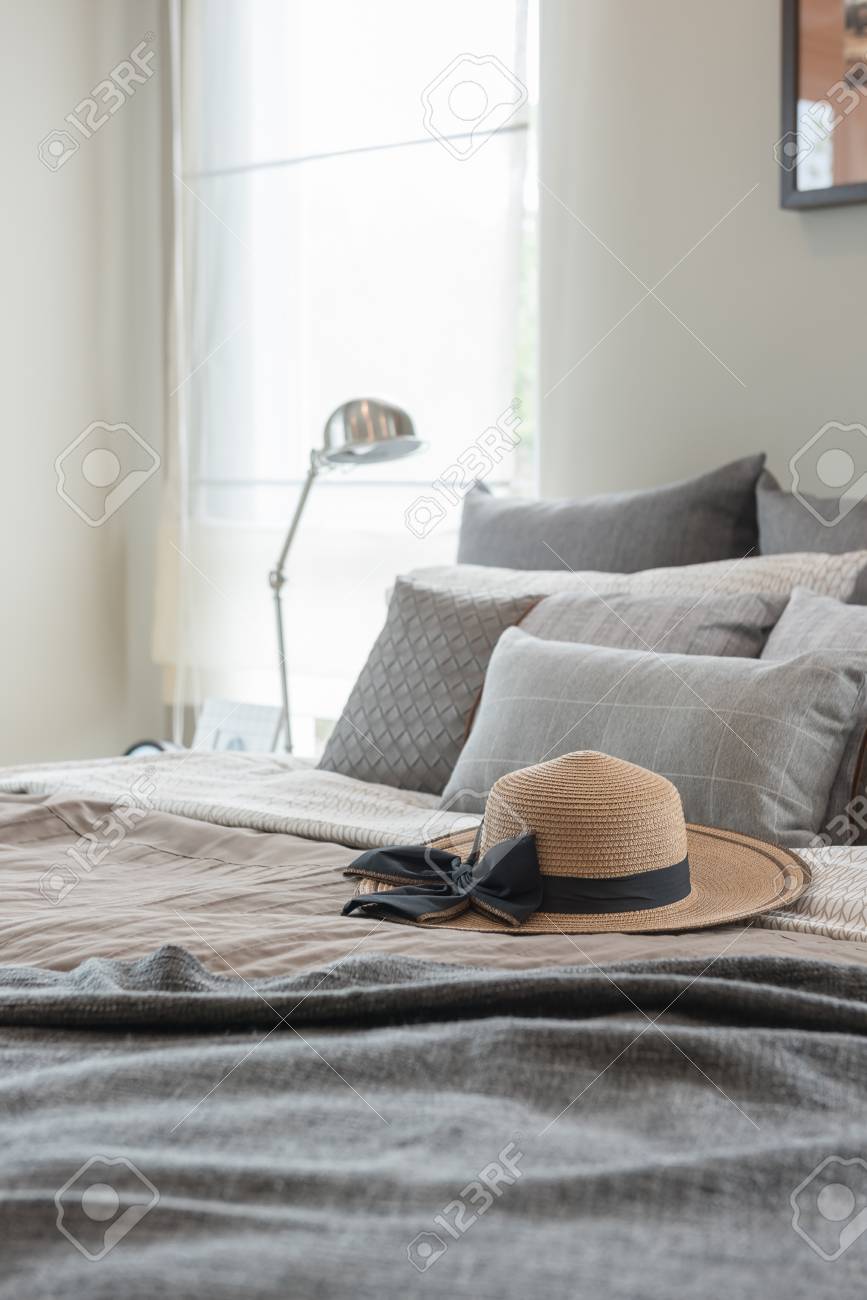 Contemporary Style Bedroom With Earth Tone Color Hat And Pillows