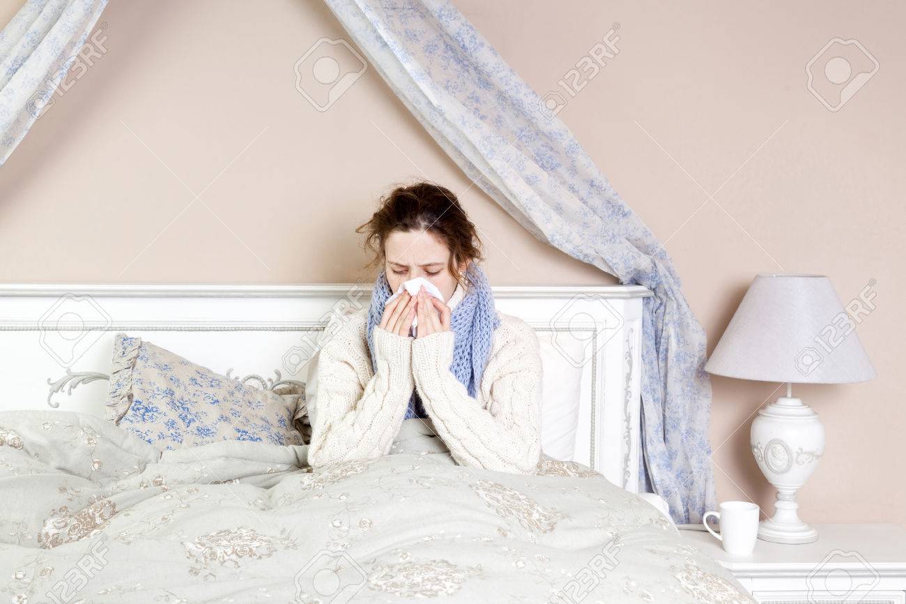 ひどい喉の痛みの病気の女性 厚いスカーフと彼女の首と頭の痛みに触れてベッドで赤い鼻を持つ若い女性のクローズ アップ画像 の写真素材 画像素材 Image