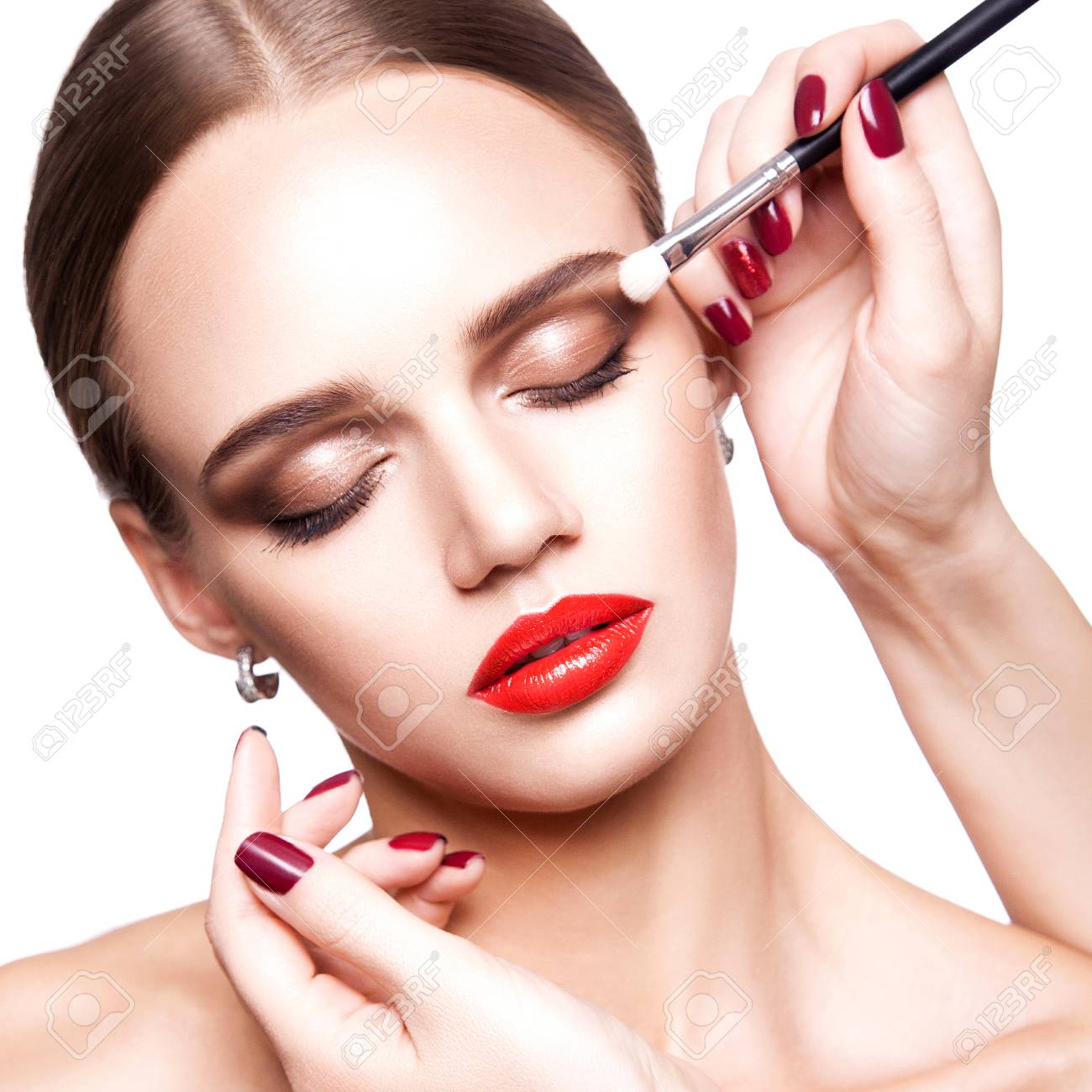 プロのメイク アーティストは 青い目と明るい茶色の髪のスタイルと完璧な肌と美しい若い女性の化粧を適用 スタジオ撮影 白い背景で隔離 の写真素材 画像素材 Image