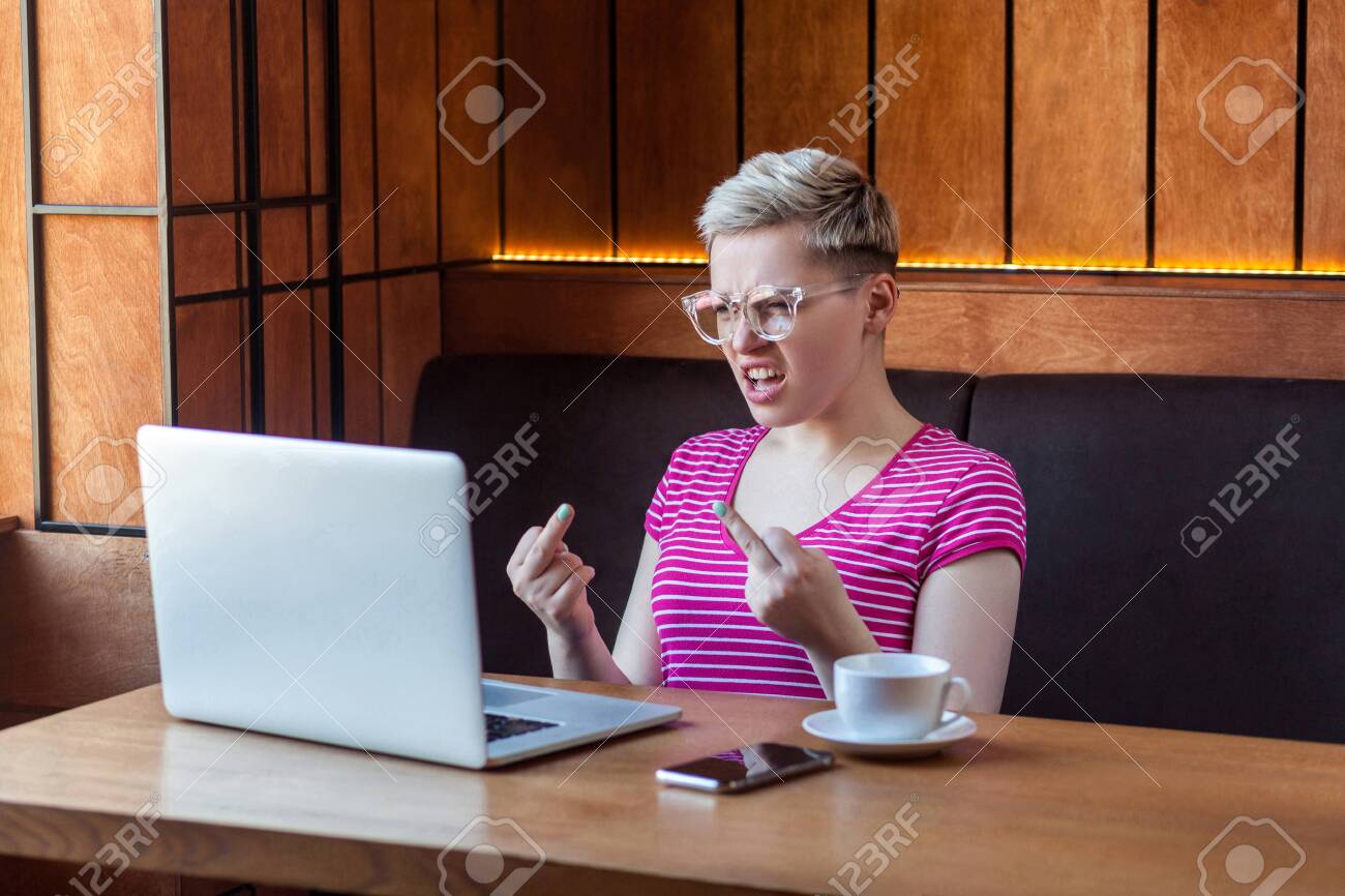 Aggressive Unhappy Young Girl Freelancer With Blonde Short Hair