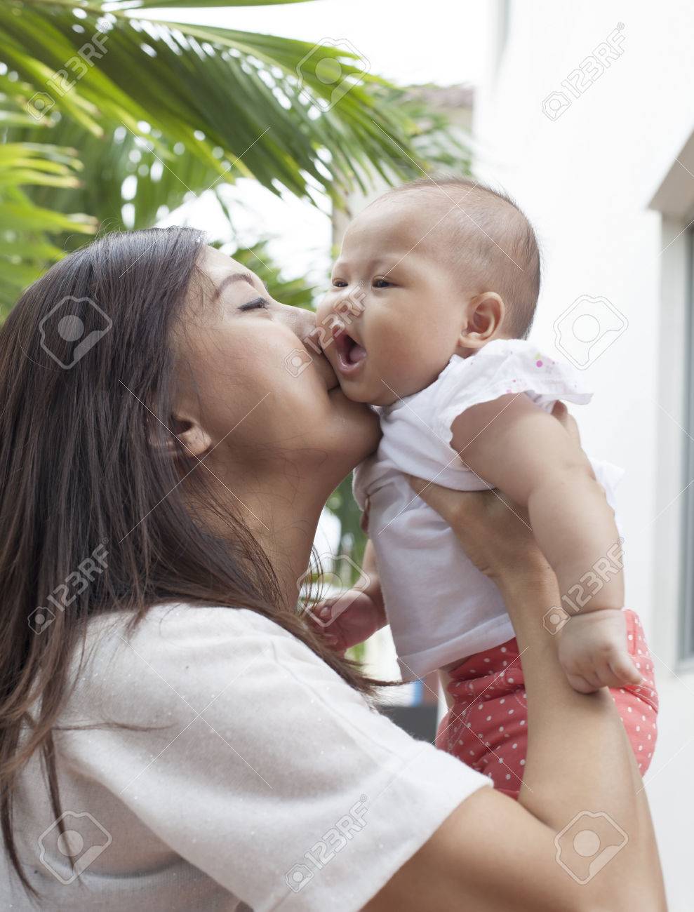 母彼女の赤ちゃん頬使用母性と温かい家族の幼児のためにキス の写真素材 画像素材 Image